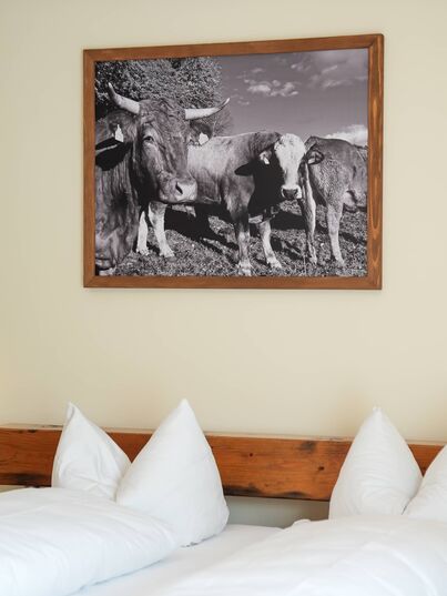 Doppelzimmer mit Holzbett und Schwarzweißbild an der Wand